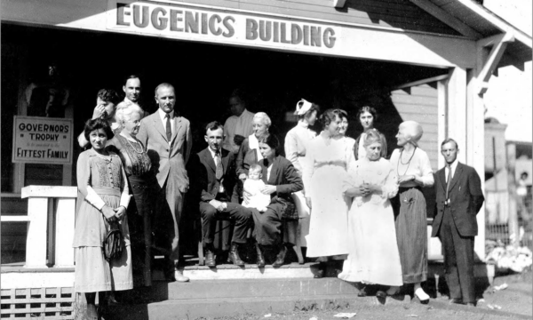 Group of people standing in front of building with "Eugenics Building" on facade
